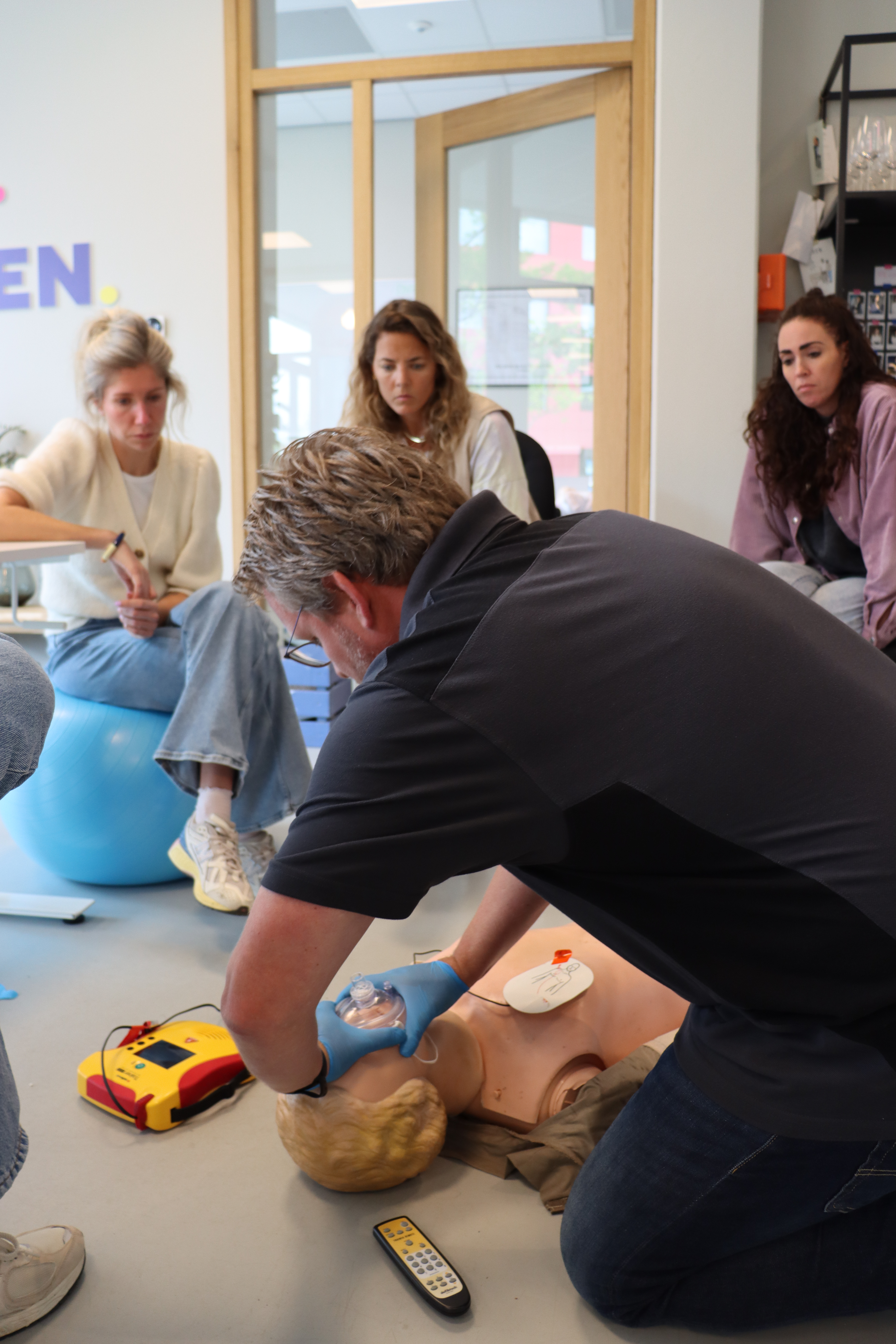 Cursisten krijgen een instructie in reanimatie van Eric staal tijdens een BHV-training.